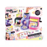 Front of the Style 4 Ever Scrapbooking Studio Pro packaging showing the purple and pink workstation with a turning handle, colourful tape rolls, craft markers, sticker decorations and a decorated scrapbook.