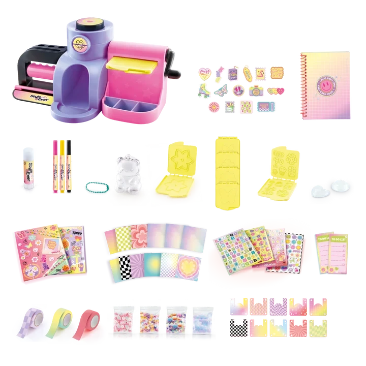 Style 4 Ever Scrapbooking Studio Pro contents arranged on a white background, including the purple and pink workstation, spiral notebook, three markers, cutting and embossing plates, decorative tapes, patterned paper, sticker sheets and packets of craft decorations.