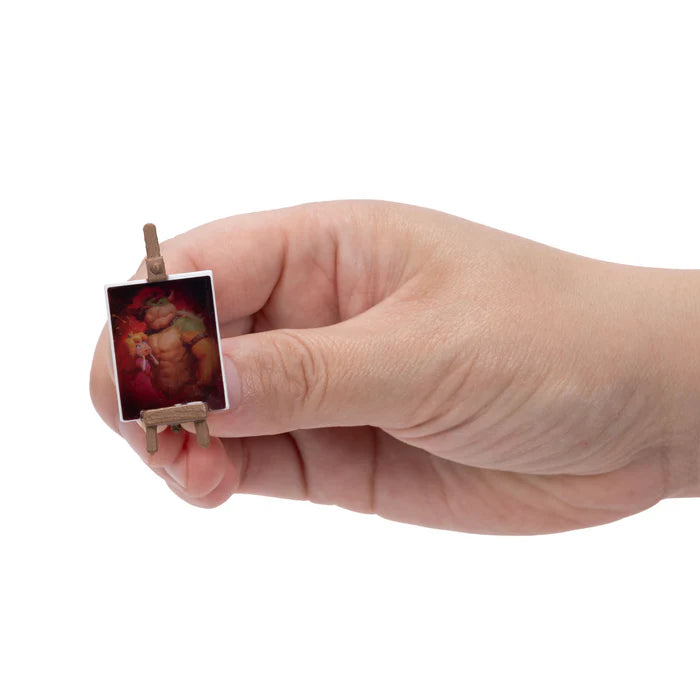 Hand holding a framed Bowser portrait accessory from the Super Mario Galaxy Movie Bowser Castle Playset