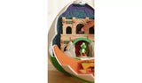 Close-up of the opened Yoshi Egg Playset showing a finger touching the dark arched castle panel, Yoshi beneath the green doorway and an orange folding section in the foreground.