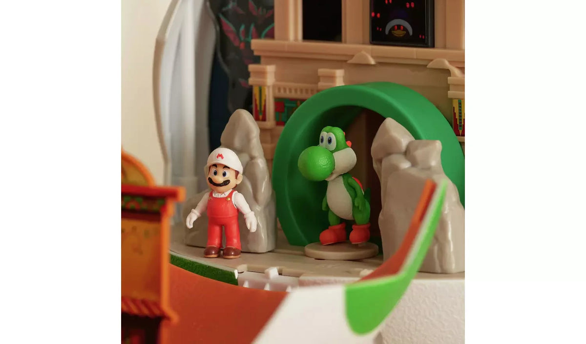 Fire Mario in red overalls and a white cap standing beside green Yoshi inside the Yoshi Egg Playset, with a castle wall, grey rocks and green archway behind them.