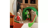 Fire Mario in red overalls and a white cap standing beside green Yoshi inside the Yoshi Egg Playset, with a castle wall, grey rocks and green archway behind them.