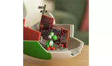 Yoshi standing inside the opened New York street section of the Yoshi Egg Playset, beside printed storefront scenery, a street sign and an orange folding panel.