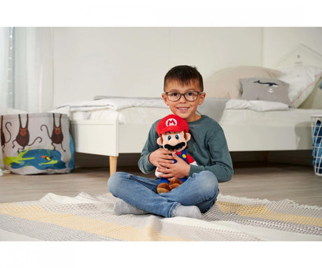 Child hugging Super Mario Mario plush toy in bedroom