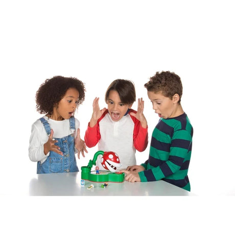 Three children sitting at a table with the Super Mario Piranha Plant Escape game