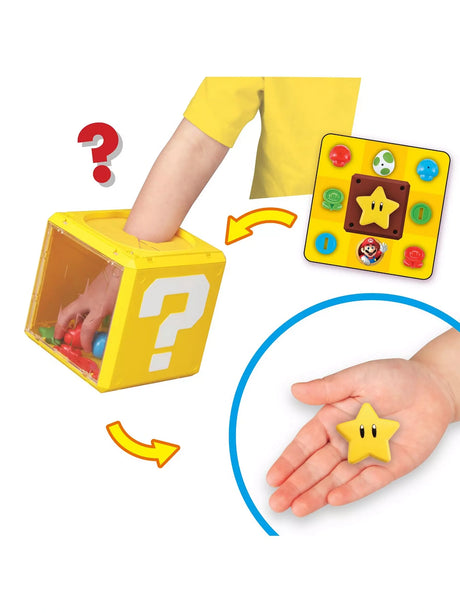 Super Mario Question Block Party Game with a hand reaching into the Question Block, an inset game card and a Super Star piece shown in a child’s hand