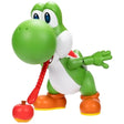Super Mario Yum Yum Yoshi figure with extended red tongue reaching towards the red fruit accessory