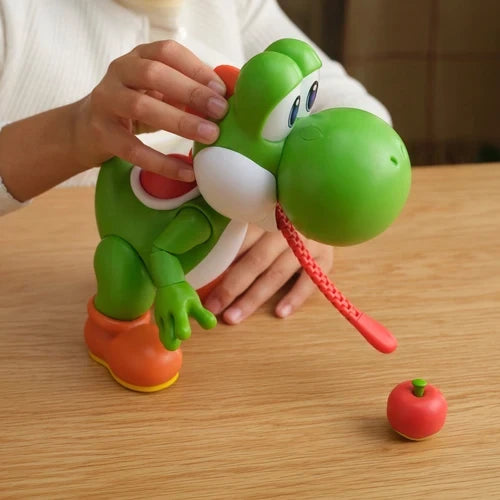 Person holding the Super Mario Yum Yum Yoshi figure with its tongue extended towards the red fruit accessory