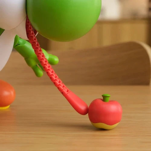 Close-up of Yum Yum Yoshi's extended red tongue touching the red fruit accessory on a table