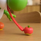 Close-up of Yum Yum Yoshi's extended red tongue touching the red fruit accessory on a table