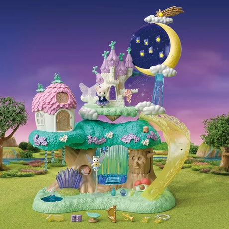 Sylvanian Families Woodland Wonder Fairy Castle in a woodland setting at twilight, showing the pink-roofed flower house, purple castle towers, crescent moon, yellow slide, blue waterfall and miniature figures.