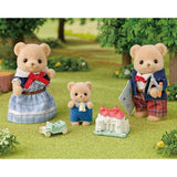 Three Biscuit Bear figures shown in a garden scene with a toy car and model house