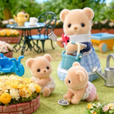 Biscuit Bear figures shown in a garden scene with a blue tricycle and green wheelbarrow