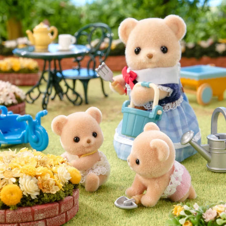 Biscuit Bear figures shown in a garden scene with a blue tricycle and green wheelbarrow