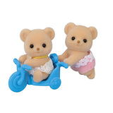 Two Biscuit Bear figures shown with a blue tricycle on a white background