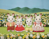 Four Chocolate Rabbit figures shown in a flower meadow with hills in the background