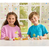 Two children sitting at a table with small Sylvanian figures and accessories