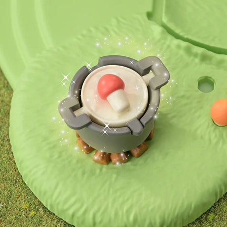 Small red capped mushroom character from the Sylvanian Families Fairy Mushroom House playset pictured among garden foliage.