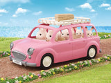 Family Picnic Van driving past flowers and sea cliffs with Chocolate Rabbit characters on a sunny day in Ireland.