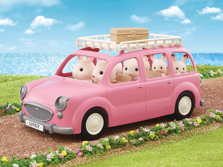 Family Picnic Van driving past flowers and sea cliffs with Chocolate Rabbit characters on a sunny day in Ireland.
