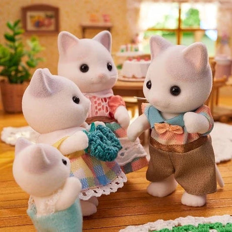 Four white cat figures shown in a room scene with a blue knitted accessory