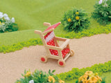 Sylvanian Families red pushchair on village path with garden background