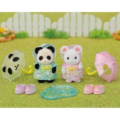 Play scene of Sylvanian Families Rainy Day Duo showing figures splashing with umbrellas, boots and puddle in Ireland.