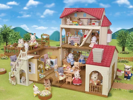 Open Sylvanian Families Red Roof Country Home shown in a garden scene with animal figures and accessories