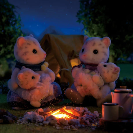 Snow Leopard figures shown at night beside a small campfire