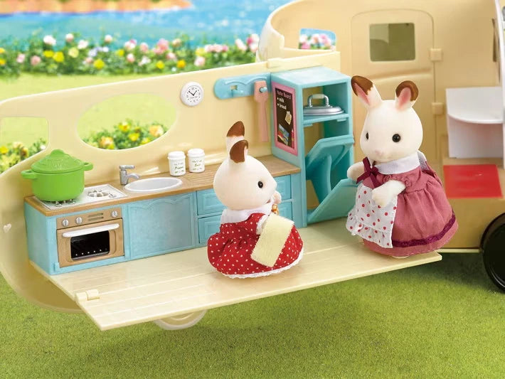 Close-up of the open caravan kitchen area with two white rabbit figures and small food accessories