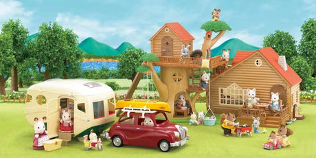 Sylvanian Families caravan and red car shown in a village scene with animal figures and a treehouse