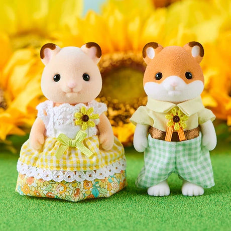 Close-up of Sylvanian Families hamster mother wearing a yellow checked dress and father wearing a cream shirt with green checked trousers, standing in front of sunflowers.