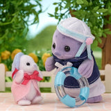 Purple Sylvanian Families seal father wearing a navy sailor outfit and holding a transparent blue swimming ring beside a white baby seal dressed in pink.