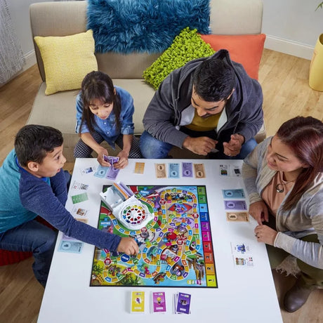 Family gathered playing The Game of Life board game at home in Ireland