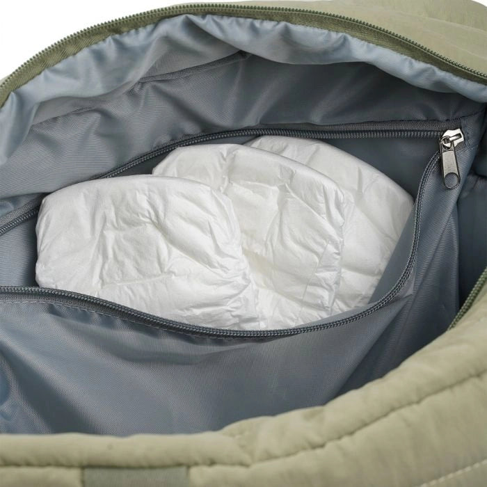 Thermobaby Pluméa Cactus Green changing bag interior with grey zip pocket and nappies stored inside.