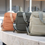 Three Thermobaby Pluméa changing bags in coral, dark green and cactus green