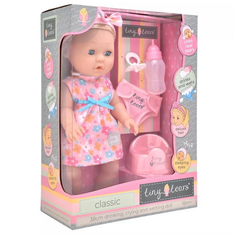Tiny Tears Classic Crying & Wetting with Hair shown in the retail box with long blonde hair, floral dress, bottle, dummy, pull up underwear and potty visible