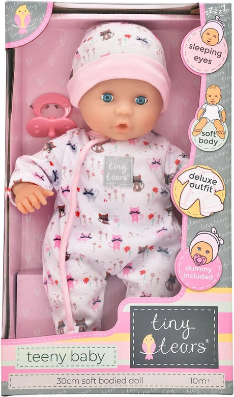 Front of the Tiny Tears Teeny Baby box showing the 30 cm soft bodied doll in a cat print outfit with sleeping eyes, soft body, deluxe outfit and dummy feature callouts