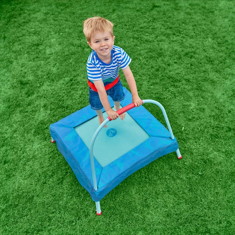 TP Junior Trampoline with child holding the handlebar on the blue padded mat