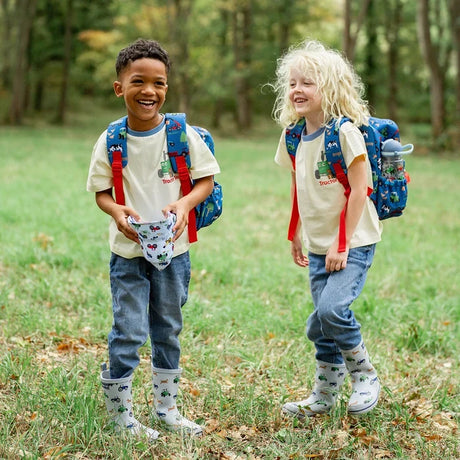 Tractor Ted Farmyard Rucksack shown outdoors among green grass and vegetation.
