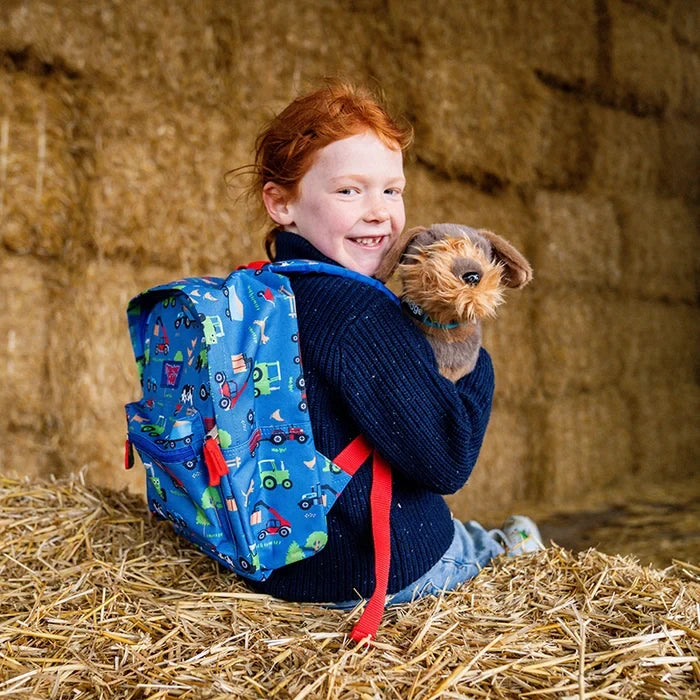 Tractor Ted character Midge in a farmyard setting with a yellow background.