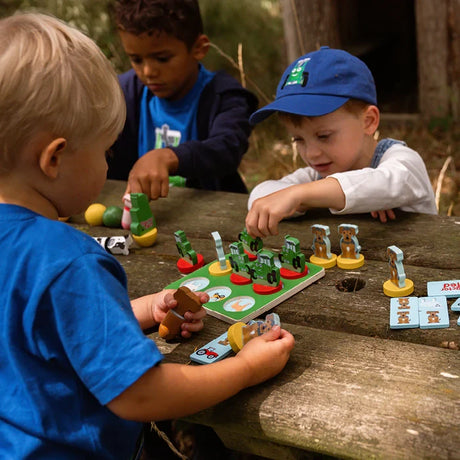 Two children playing Tractor Ted wooden Tic Tac Toe at a table with game board and pieces visible
