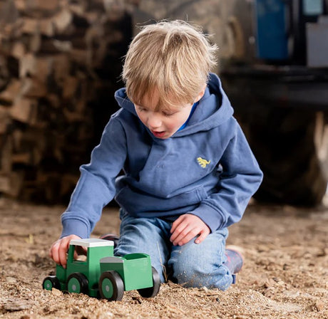 Child playing with Tractor Ted Toy and Trailer on the ground Ireland