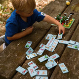 Child playing with Tractor Ted Wooden Farm Dominoes on wooden table matching farm animal and tractor pieces