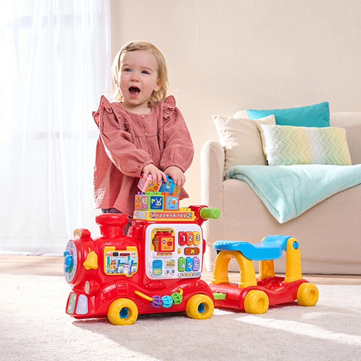 Child using the VTech 4-In-1 Alphabet Express with learning blocks on top and pull cart attached