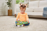 Baby sitting on carpet holding VTech Animal Rhymes Storytime book open on lap