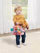 Toddler carrying the VTech Baby Cutie Puppy Carrier by its purple handle, showing pink carrier with plush puppy and interactive activity panel