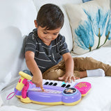 Child pressing the controls and piano keys on the VTech Bluey Sing-Along Keyboard while seated on a sofa