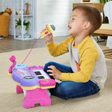 Child singing into the yellow microphone while playing the VTech Bluey Sing-Along Keyboard on the floor
