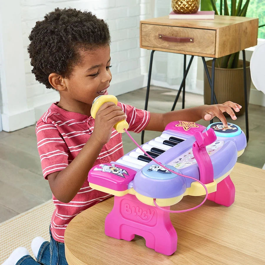 Child singing into the microphone while pressing a character control on the VTech Bluey Sing-Along Keyboard